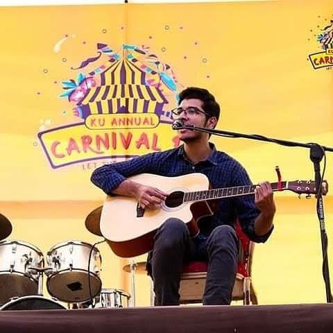 Raza Haider performing with guitar at the KU Annual Carnival